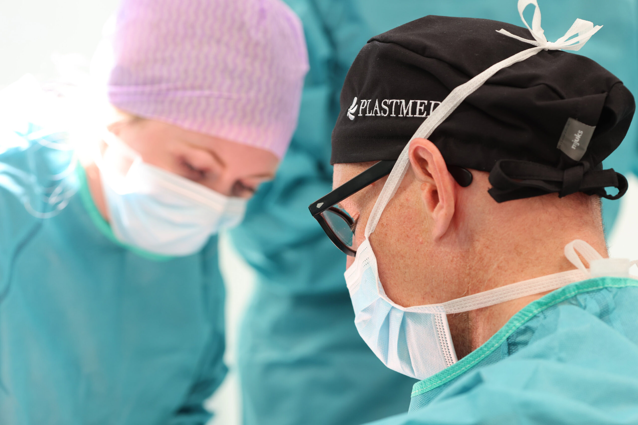 Einblick in den OP-Bereich bei Plastmed Düsseldorf mit mehreren Ärzten und Assistentinnen in Kitteln
