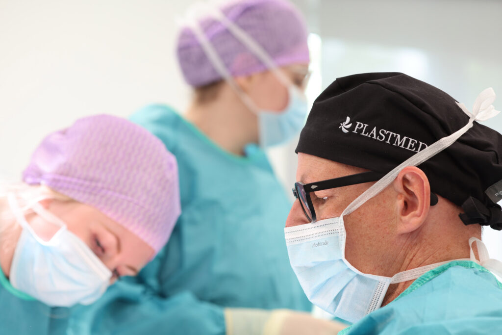 Einblick in den OP-Bereich bei Plastmed Düsseldorf mit mehreren Ärzten und Assistentinnen in Kitteln