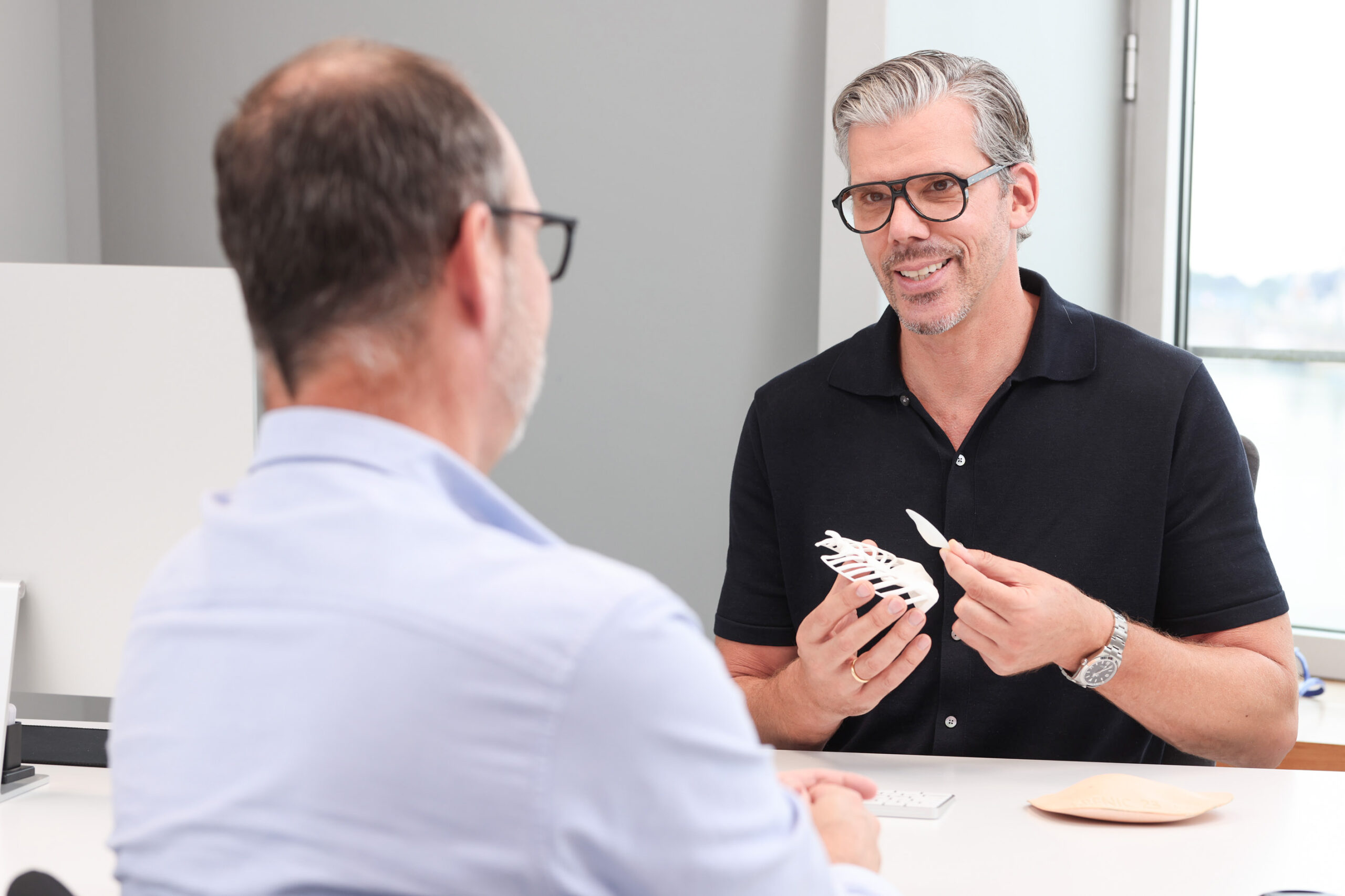 Mann wird vor einer Brustkorrektur bei Plastmed Düsseldorf untersucht von Dr. med. Till Scholz, der seine Brust ausmisst